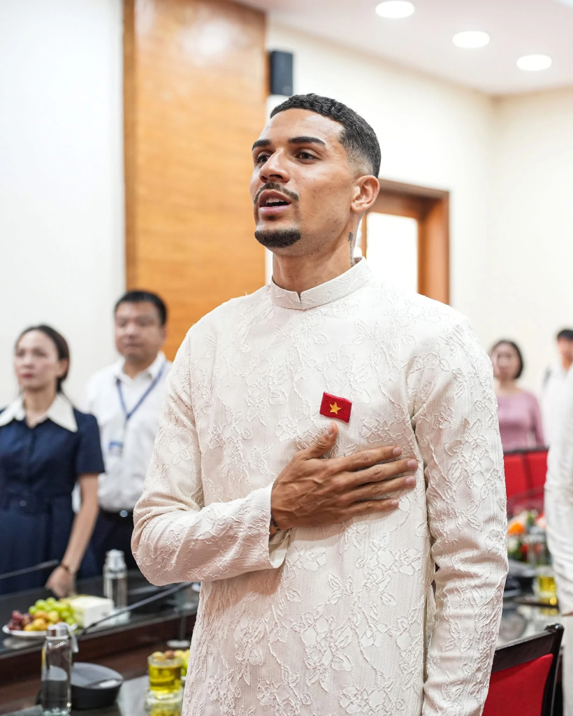 Trong tà áo dài truyền thống, Đỗ Hoàn Hên cất cao tiếng hát Quốc ca Việt Nam một cách trôi chảy. Ảnh : Hà Nội FC